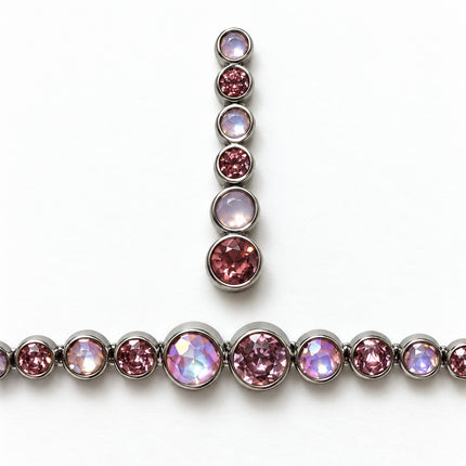 Dettaglio delle pietre tonde rosa e lilla del bracciale e di un orecchino, con montature circolari color argento.