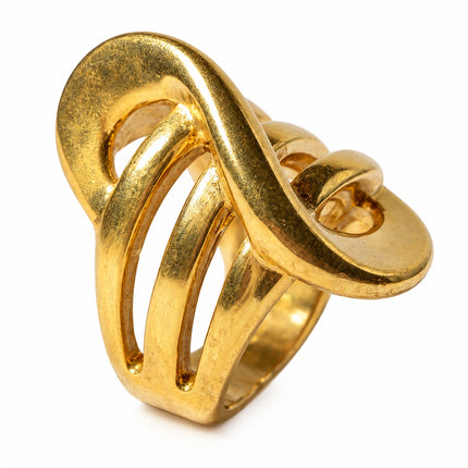 Dettaglio del motivo sinuoso e delle aperture dell'anello donna dorato.