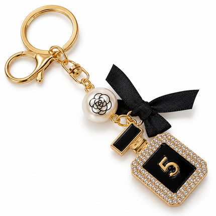 Portachiavi accessorio borsa dorato con pendente nero numero 5, cristalli e charm perlato, vista diagonale