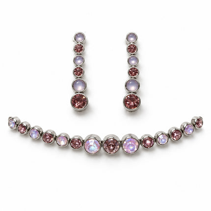 Set bracciale e orecchini in acciaio nella variante rosa e chiara, fotografato a tre quarti su fondo bianco.