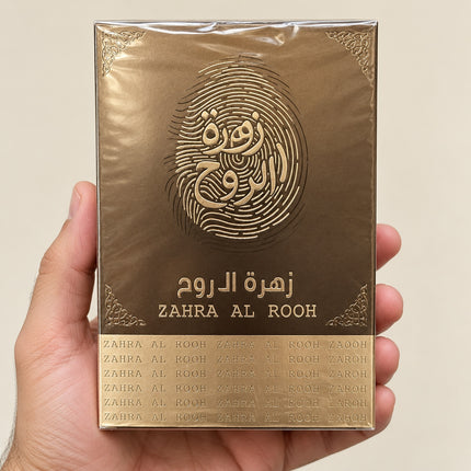 Confezione del profumo Zahra Al Rooh tenuta in mano su sfondo neutro.