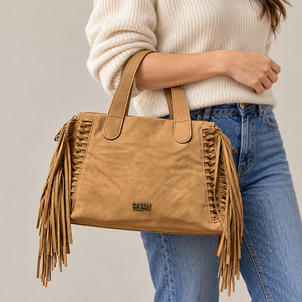 Borsa Enrico Coveri cammello con frange portata all’avambraccio con abbigliamento casual.