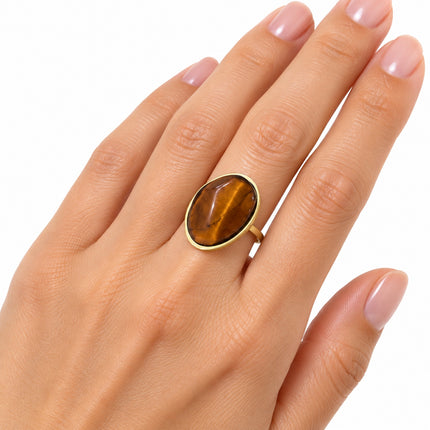 Anello donna Shelly con pietra occhio di tigre e montatura dorata indossato al dito.