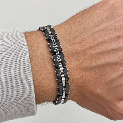 Bracciale con pietre nere indossato al polso maschile, simulazione visiva.