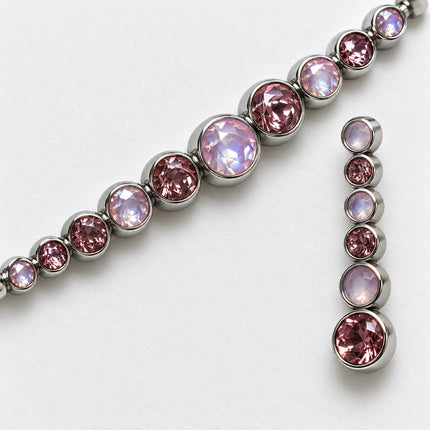 Particolare delle montature tonde in acciaio e dei collegamenti del bracciale e dell'orecchino.