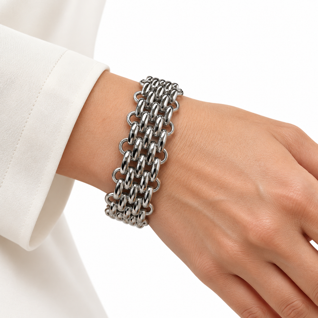Bracciale largo color argento con intreccio geometrico indossato al polso