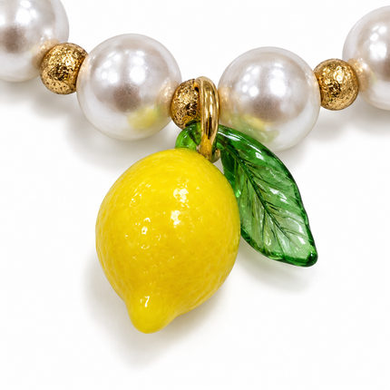 Dettaglio pendente limone giallo con foglia verde e perle bianche