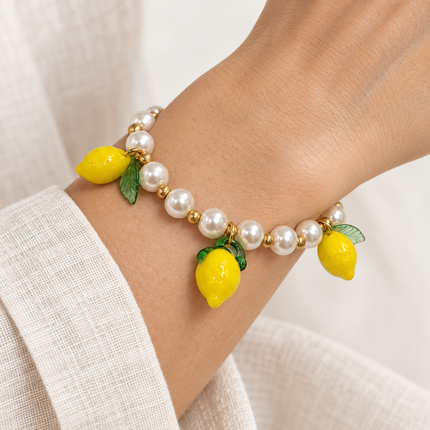Bracciale con perle e pendenti limone indossato al polso