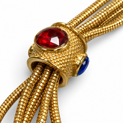 Dettaglio elementi in vetro rosso e blu del bracciale dorato