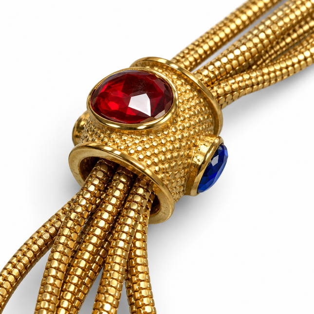Dettaglio elementi in vetro rosso e blu del bracciale dorato