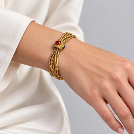 Bracciale multifilo dorato con vetro colorato indossato al polso