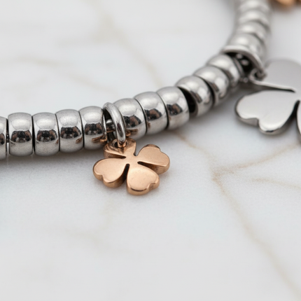 Dettaglio ciondolo quadrifoglio portafortuna in oro rosa su bracciale acciaio 2JEWELS