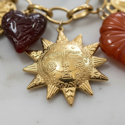Dettaglio macro ciondolo sole oro: incisioni artigianali e texture