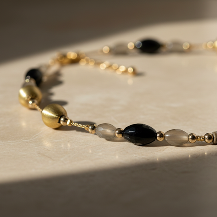 Dettaglio perle nere lucide e elementi metallici collana sautoir
