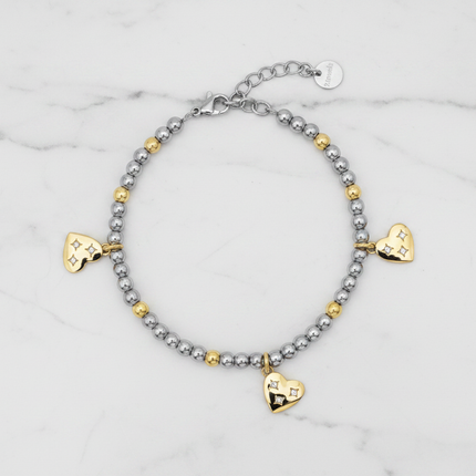 Flat lay bracciale 2JEWELS 232347 sfere bicolore e cuori gold vista dall'alto su marmo