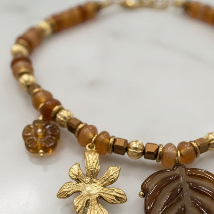 Tempo A Tempo boho chic necklace featuring amber-toned beads and gold-tone flower and leaf charms