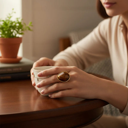 Anello donna Shelly di Tempo A Tempo in acciaio dorato con pietra naturale occhio di tigre, indossato su una mano