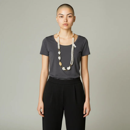 Tempo A Tempo long necklace with cultured baroque pearls and gold-tone accents worn by a model in a grey t-shirt