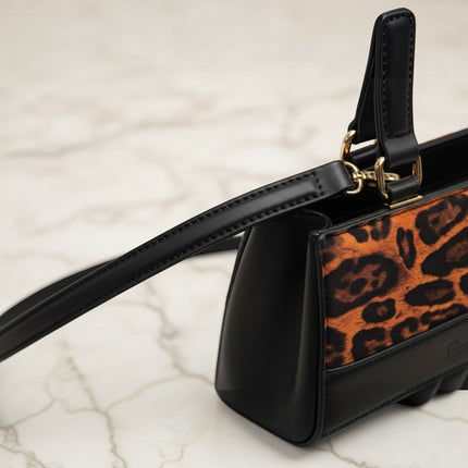 Tempo A Tempo black leather handbag with leopard print panel and adjustable shoulder strap.