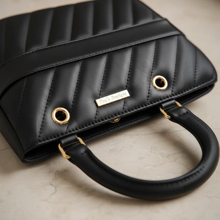 Tempo A Tempo black quilted leather handbag with gold hardware and a top handle.