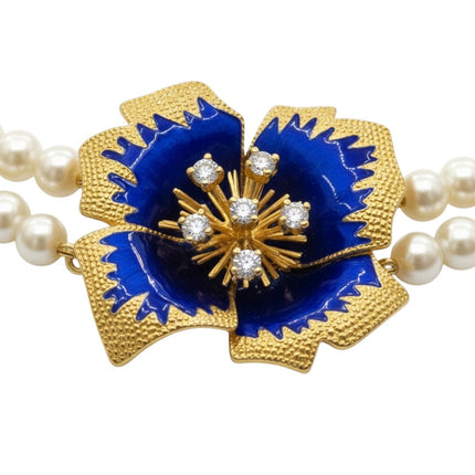 Tempo A Tempo Shelly double strand pearl necklace featuring a blue enamel flower pendant with gold baroque details