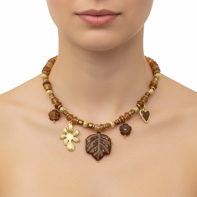Tempo A Tempo Shelly boho chic necklace featuring amber-toned beads and gold-tone leaf and flower charms on a model.