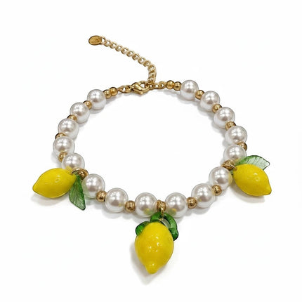 Tempo A Tempo bracciale donna con perle bianche, perline dorate in acciaio e 3 charms limone gialli con foglie verdi. Chiusura ad aragosta.