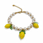 Tempo A Tempo bracciale donna con perle bianche, perline dorate in acciaio e 3 charms limone gialli con foglie verdi. Chiusura ad aragosta.