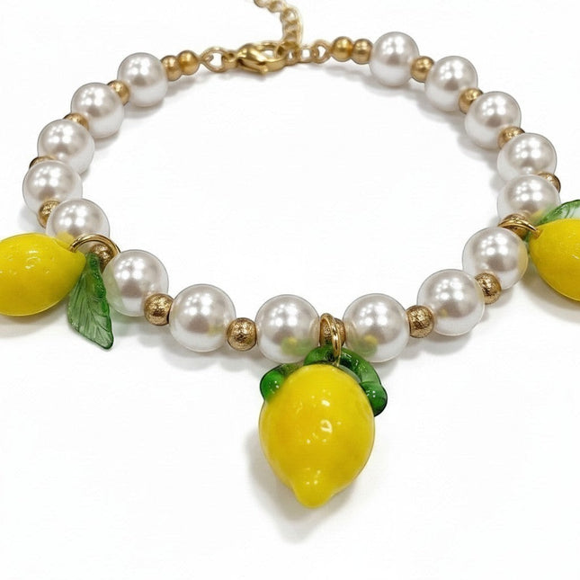 Tempo A Tempo bracciale donna con perle bianche, perline dorate in acciaio e 3 charms limone gialli con foglie verdi. Chiusura ad aragosta.