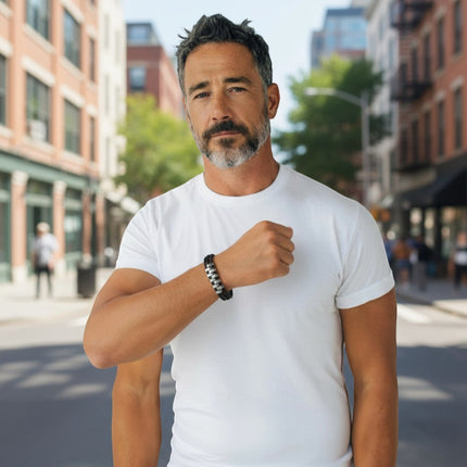 Uomo con bracciale Tempo A Tempo intrecciato nero e acciaio inox, stile casual urbano in un contesto cittadino