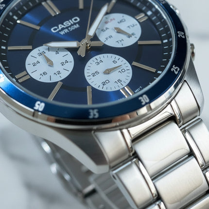 Tempo A Tempo Casio MTP-1374D watch with a blue multifunction dial and stainless steel bracelet in a close-up view
