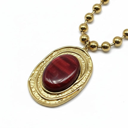 Tempo A Tempo collana da donna in acciaio dorato con catena a sfere e ciondolo ovale con resina rossa martellata.