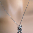 Collana Tempo A Tempo in metallo argentato con ciondolo a forma di gatto stilizzato indossata su manichino