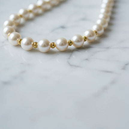 Tempo A Tempo collana lunga con perle bianche sintetiche, distanziatori dorati e ciondolo a croce con madreperla.