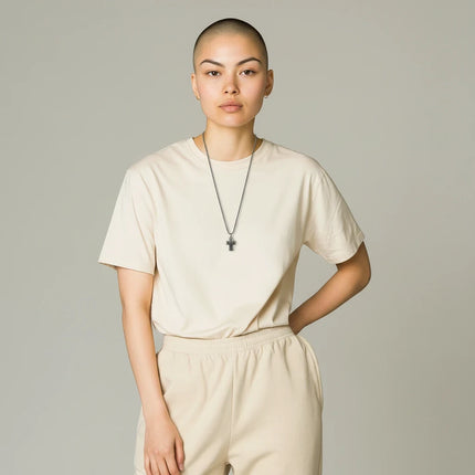 Modella indossa collana Tempo A Tempo 2Jewels in acciaio IP nero con ciondolo a forma di crocifisso su t-shirt beige