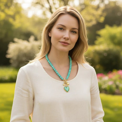Modella indossa collana Tempo A Tempo in perline resina verde tiffany con ciondoli cuore e stella in acciaio dorato