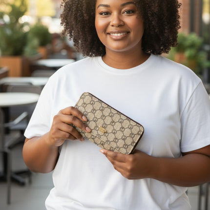 Tempo A Tempo woman holding a beige Coveri World trifold wallet with an elegant monogram pattern in an outdoor setting