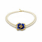 Tempo A Tempo Shelly double-strand pearl necklace with a blue enamel flower pendant and gold baroque accents.