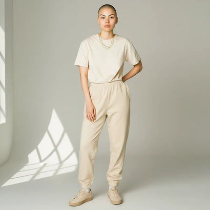 Tempo A Tempo gold necklace with interlocking circles worn by a model in a beige t-shirt and matching sweatpants.