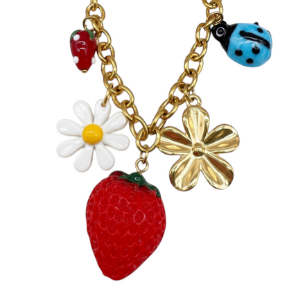 Tempo A Tempo gold-tone stainless steel bracelet with strawberry, ladybug, daisy, and flower charms. Adjustable.