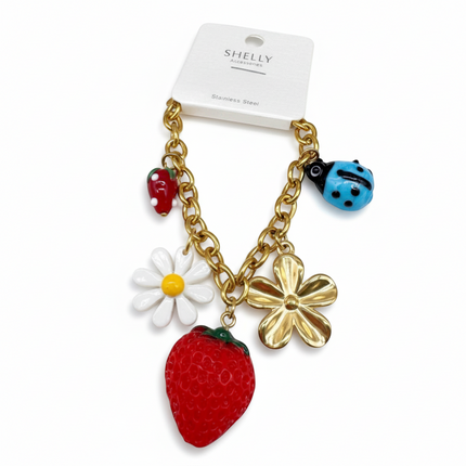 Tempo A Tempo gold-tone stainless steel bracelet with strawberry, ladybug, daisy, and flower charms. Adjustable.