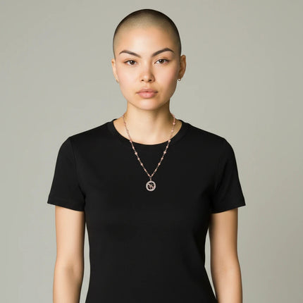 Tempo A Tempo Guess gold-tone stainless steel necklace with an intertwined hearts pendant worn by a model.