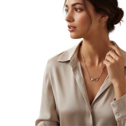 Tempo A Tempo GUESS rose gold infinity pendant necklace worn by a woman in a beige silk shirt