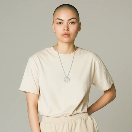 Tempo A Tempo Guess silver steel necklace with crystal-embellished logo pendant worn by a model in a beige t-shirt