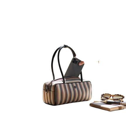 Mini bag Tempo A Tempo Regina Schrecker in tessuto jacquard a righe multicolor con manico in pelle su un tavolo
