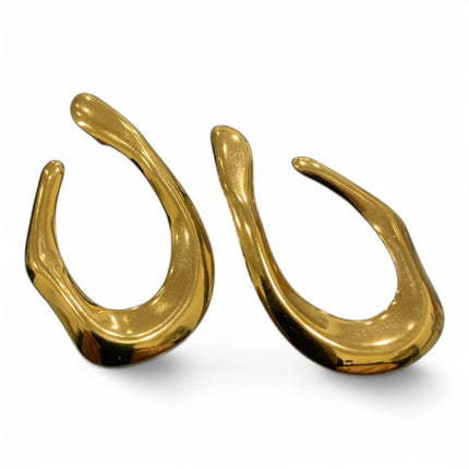 Orecchini Tempo A Tempo in acciaio dorato lucido con design scultoreo asimmetrico e forma fluida moderna