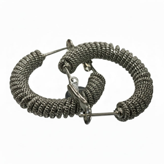 Orecchini a cerchio Tempo A Tempo in acciaio argentato con design a spirale intrecciata e finitura testurizzata.