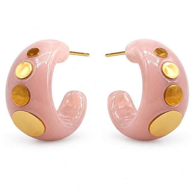 Orecchini a cerchio maxi Tempo A Tempo in resina lucida rosa cipria con borchie dorate scalari, design rock-chic.