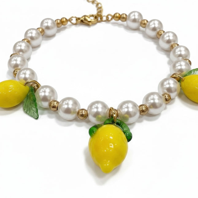 Tempo A Tempo gold-tone bracelet with white pearls, gold beads, and three yellow lemon charms with green leaves.