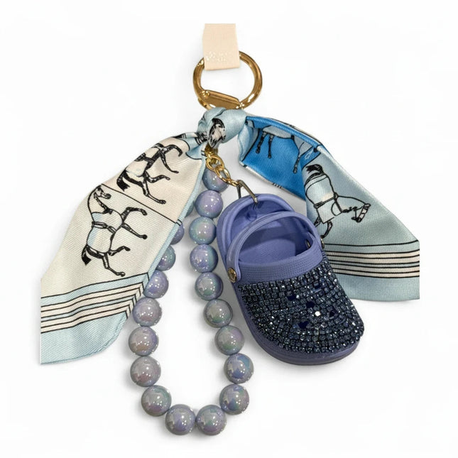 Portachiavi Tempo A Tempo con mini Crocs lilla, cristalli Swarovski, foulard stampa cavalli e perle opalescenti.